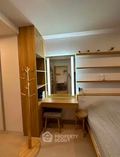 Modern bedroom with wooden furniture and built-in shelves, featuring a stylish vanity mirror.