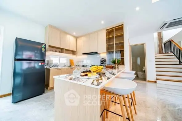 Modern kitchen with marble island and sleek appliances in open layout