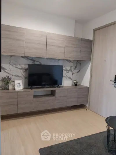 Modern living room with sleek wooden cabinetry and marble accent wall