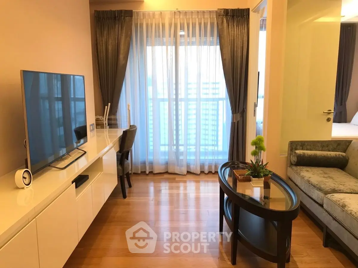 Modern living room with sleek furniture and large window for natural light.