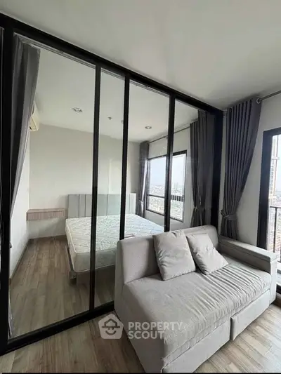 Modern bedroom with glass partition and cozy sofa in a stylish apartment
