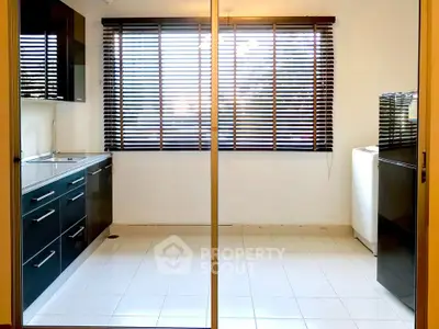 Spacious kitchen with sleek cabinetry and large windows for natural light.