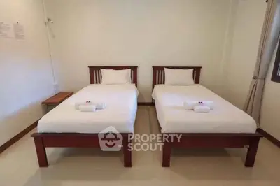 Cozy twin bedroom with simple decor and natural light.