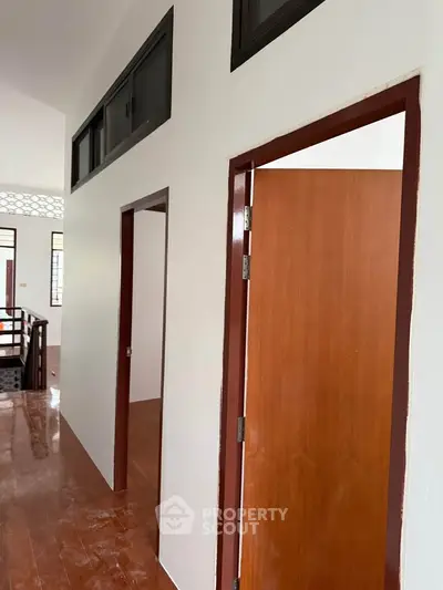 Spacious hallway with wooden doors and elegant flooring in a modern home
