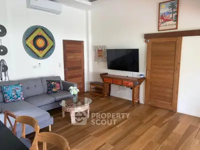 Charming living room with wooden flooring, stylish decor, and modern furniture in a cozy home setting.