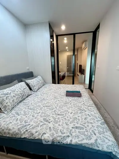 Modern bedroom with stylish decor and glass partition leading to living area.