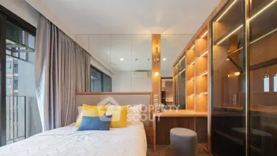 Modern bedroom with stylish lighting and mirrored wardrobe in a luxury apartment.