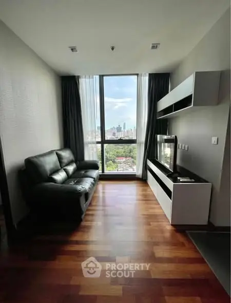 Modern living room with city view, sleek furniture, and wooden flooring.