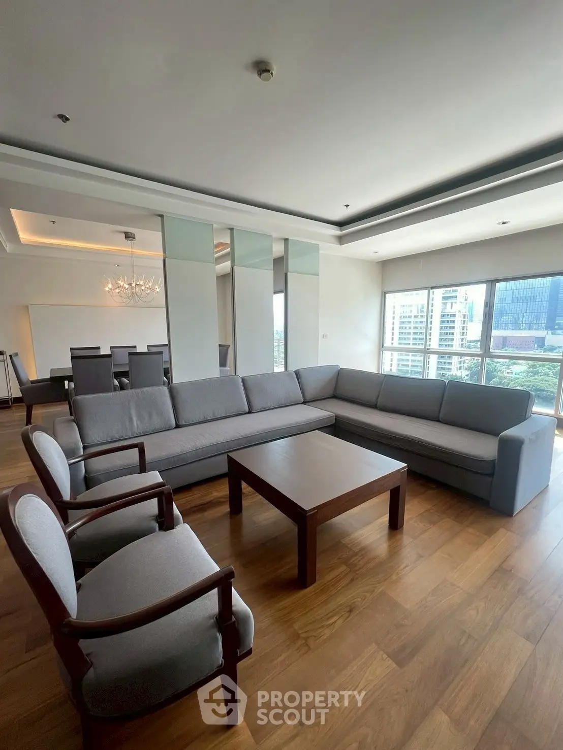 Spacious living room with elegant furniture and city view, perfect for modern urban living.