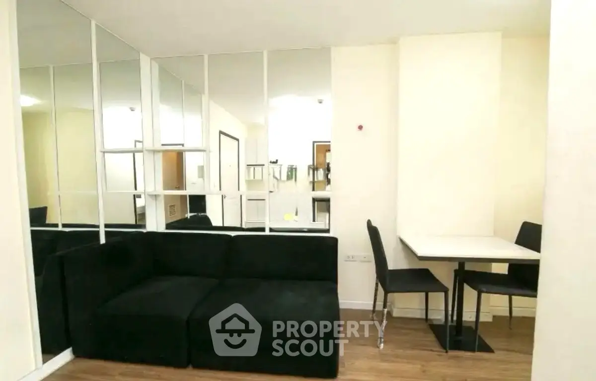 Modern living room with black sofa and mirrored wall design