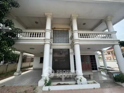 Elegant two-story house with classic columns and spacious balcony