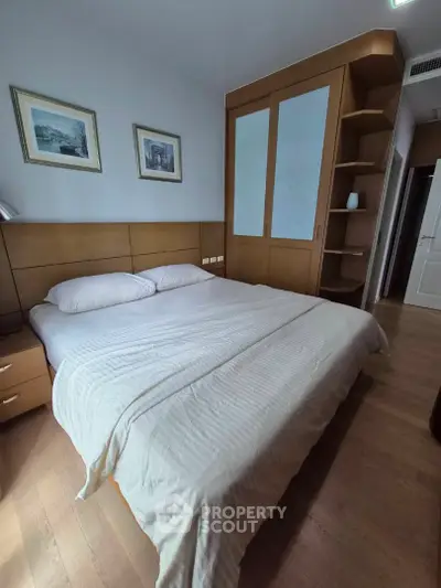 Cozy bedroom with wooden furniture and elegant decor, perfect for relaxation and comfort.