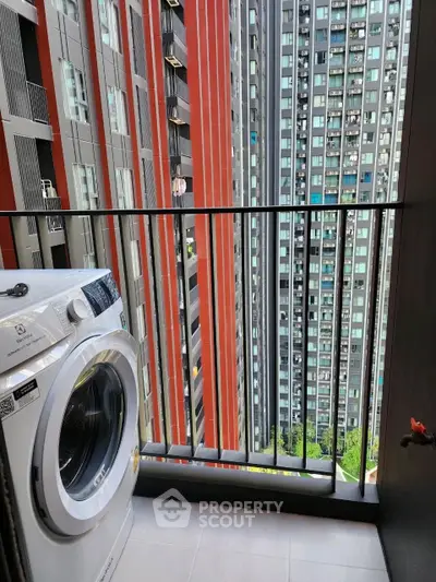 Modern high-rise balcony with washing machine and city view