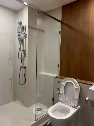 Modern bathroom with glass shower and sleek wooden accents