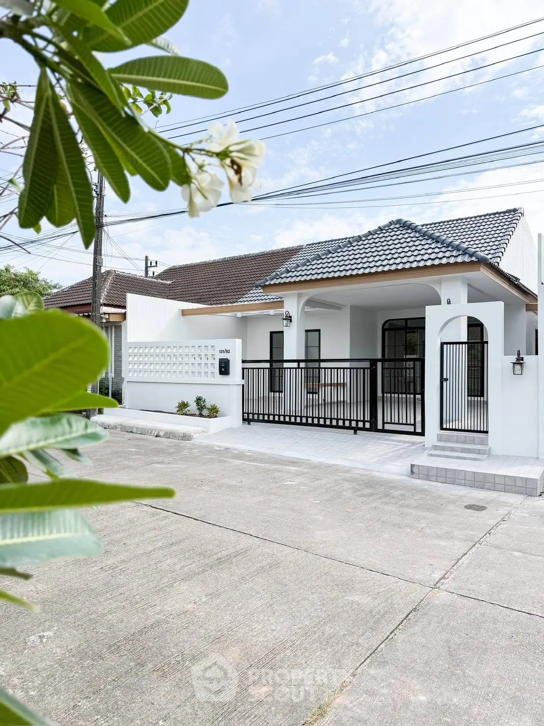 Charming modern house with gated entrance and lush greenery