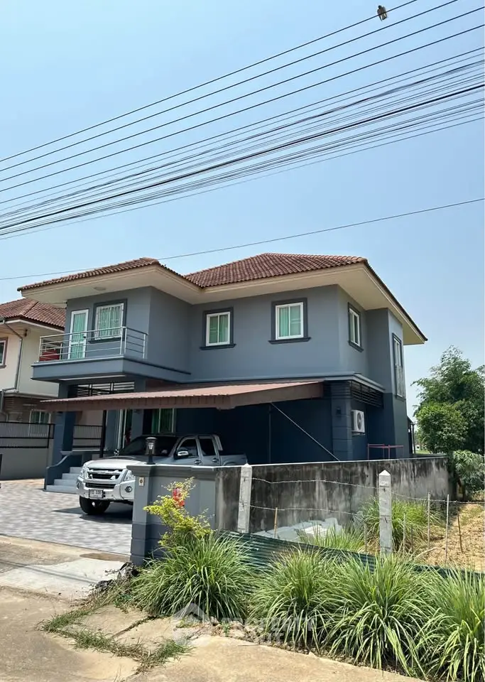 Charming two-story blue house with a spacious driveway and lush greenery, perfect for family living.