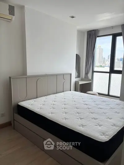 Modern bedroom with city view, featuring a stylish bed and large window for natural light.