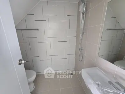 Modern bathroom with sleek tile design and contemporary fixtures.