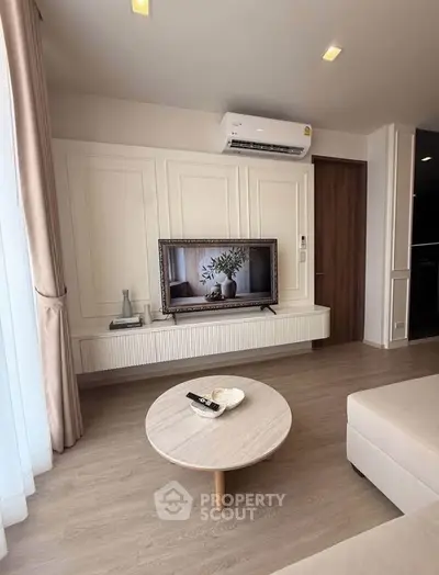 Modern living room with sleek TV setup and stylish decor in a cozy apartment.