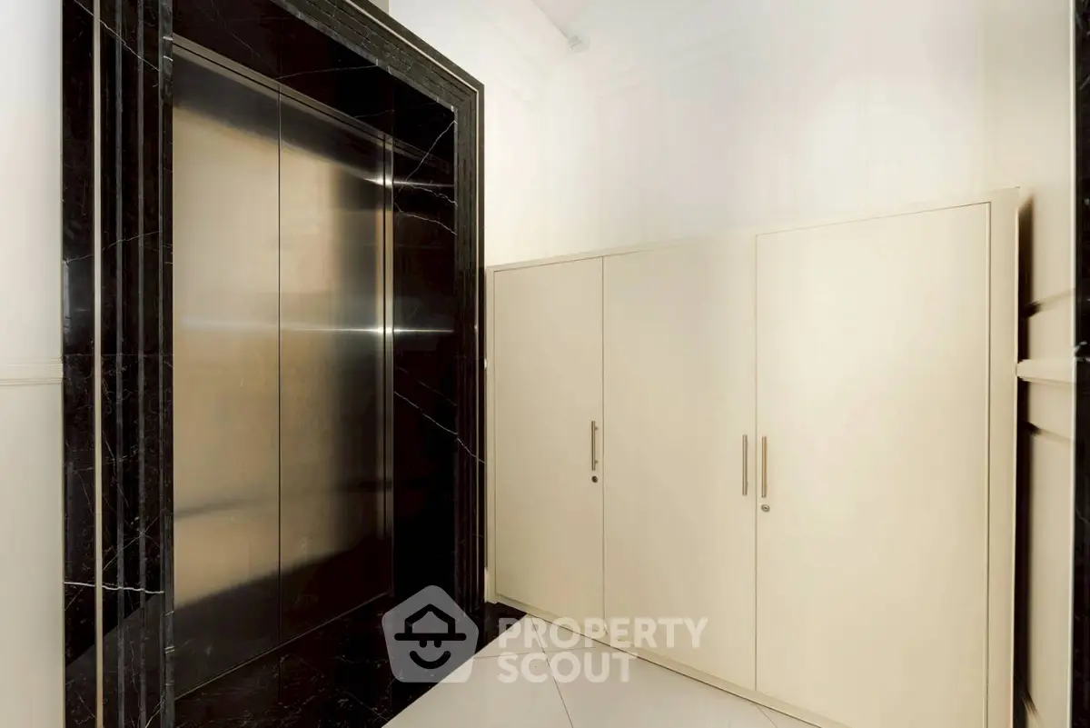 Luxurious modern elevator with sleek black marble surround in upscale building.