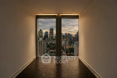 Stunning city view from a modern high-rise apartment with floor-to-ceiling windows.