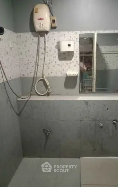 Functional bathroom with shower and water heater in a modern apartment.
