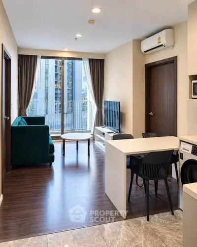 Modern living room with open kitchen and balcony view in a stylish apartment.