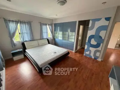 Spacious bedroom with modern decor and large windows for natural light