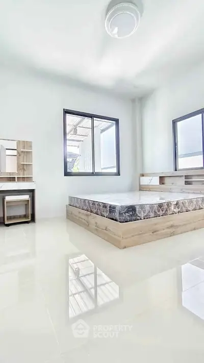 Bright and spacious bedroom with modern furnishings and large windows.