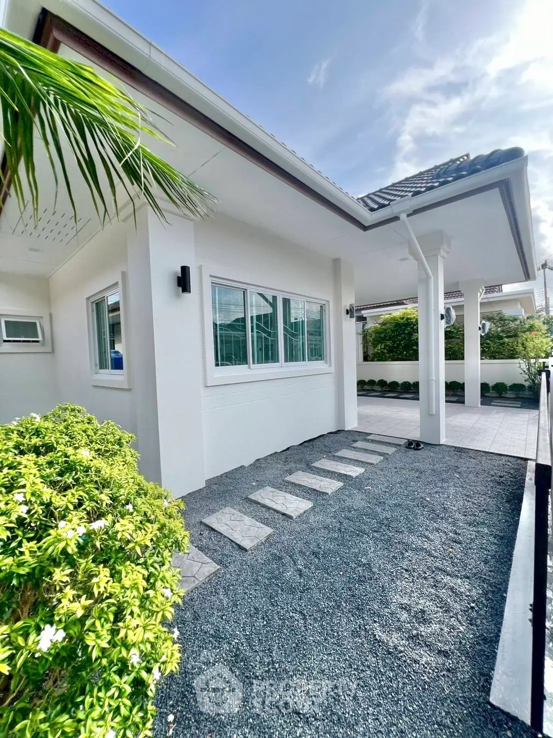 Charming modern house exterior with lush greenery and stylish pathway