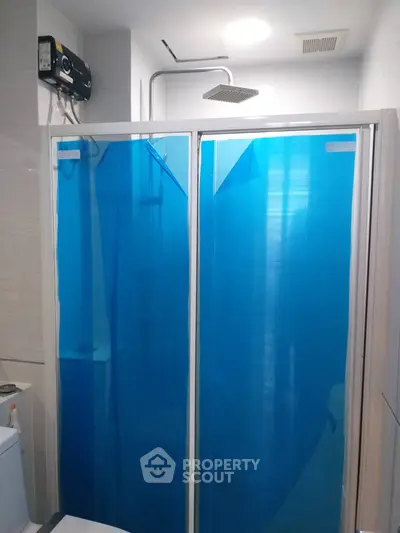Modern bathroom with sleek shower enclosure and overhead rain shower.