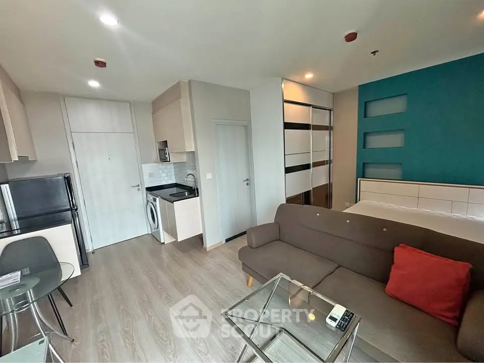 Modern studio apartment with open layout, featuring a cozy living area, compact kitchen, and stylish decor.