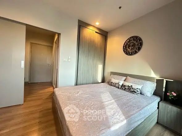 Cozy bedroom with modern decor and natural light, featuring a stylish bed and wooden flooring.