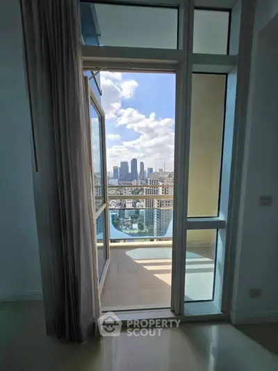 Stunning city view from a modern apartment balcony with floor-to-ceiling windows.