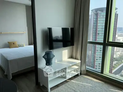 Modern apartment with bedroom and city view, featuring sleek TV setup and large windows.