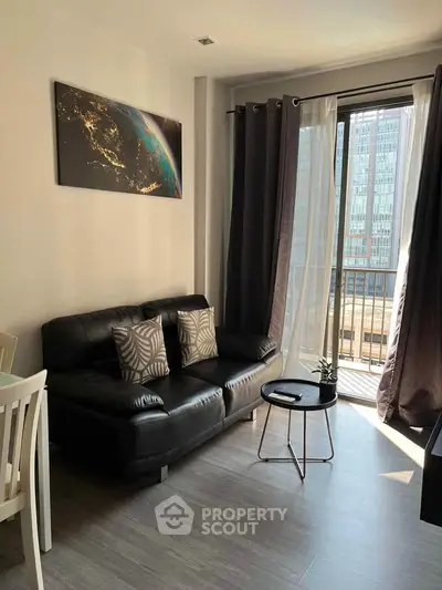 Modern living room with black leather sofa and city view balcony, perfect for urban living.