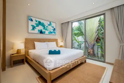 Luxurious bedroom with modern decor and garden view in a serene setting.