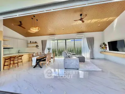 Spacious modern living room with open kitchen, high ceilings, and elegant decor.