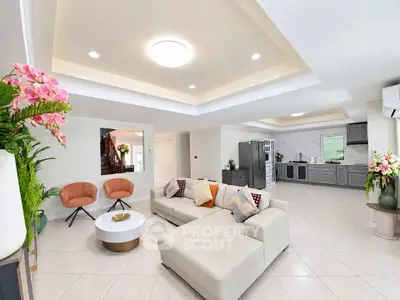 Spacious modern living room with open kitchen, elegant decor, and ample natural light.