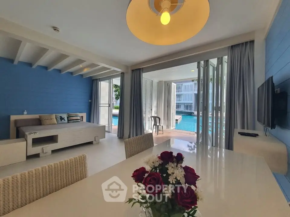 Luxurious living room with pool view, modern decor, and elegant dining area in a stunning real estate property.