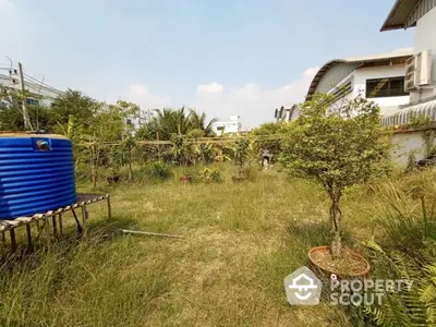 Spacious garden area with lush greenery and modern architecture in the background.