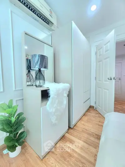 Modern bedroom with sleek white furniture and wooden flooring