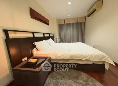 Cozy bedroom with modern decor and ambient lighting, featuring a comfortable bed and stylish nightstand.