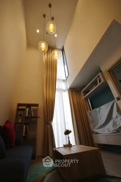 Modern living room with high ceiling and elegant lighting