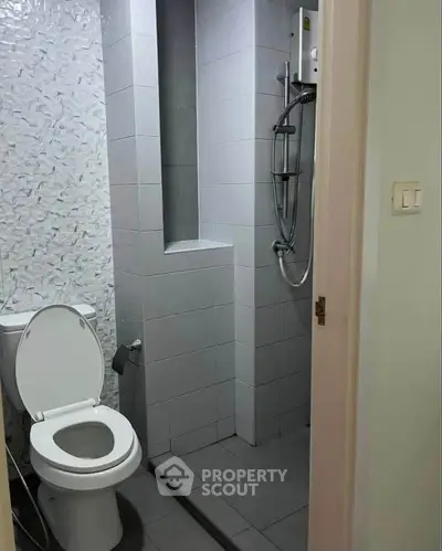 Compact bathroom with modern shower and tiled walls, ideal for urban living spaces.