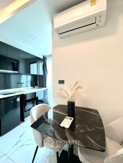 Modern kitchen with sleek black cabinets and marble dining table