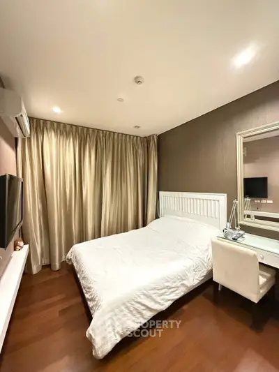 Elegant bedroom with modern decor, featuring a cozy bed, stylish curtains, and a sleek TV setup.