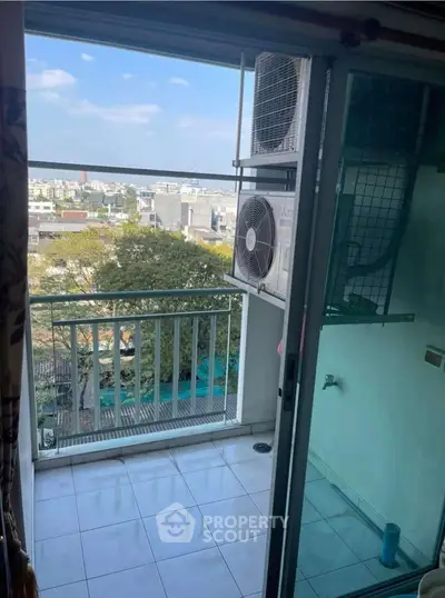 Charming balcony with city view and air conditioning unit, perfect for relaxation.
