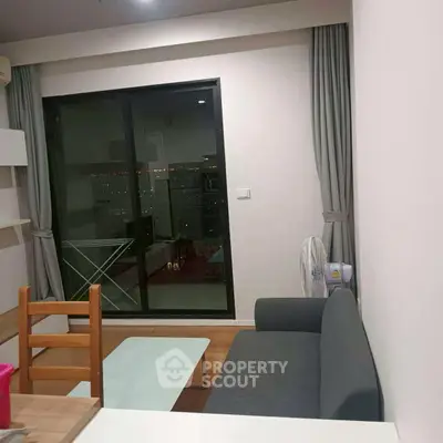 Cozy living room with modern furniture and city view balcony access.