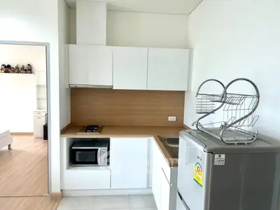 Modern compact kitchen with sleek cabinetry and appliances in a stylish apartment.